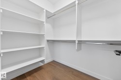 Walk in closet featuring dark wood finished floors - 