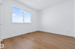 Spare room featuring light wood finished floors and vaulted ceiling - 