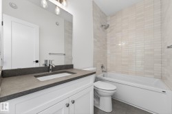 Full bathroom with shower / bath combination, vanity, and dark tile patterned flooring - 