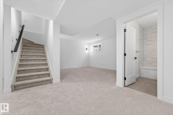 Below grade area with light carpet and stairway - 