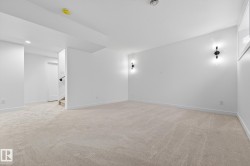 Spare room featuring light colored carpet, stairs, and recessed lighting - 