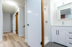 Full bath featuring a marble finish shower, vanity, and dark wood finished floors - 