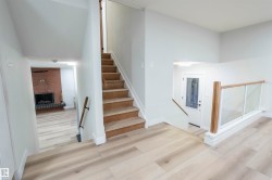 Staircase featuring wood finished floors and a fireplace - 