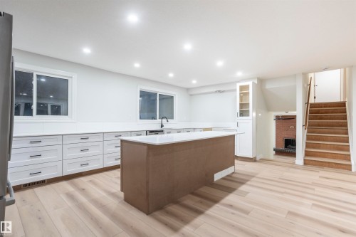 Kitchen with white cabinetry, glass insert cabinets, a center island, light wood-style floors, and recessed lighting - 47 Manor Drive, Sherwood Park, AB - Indoor