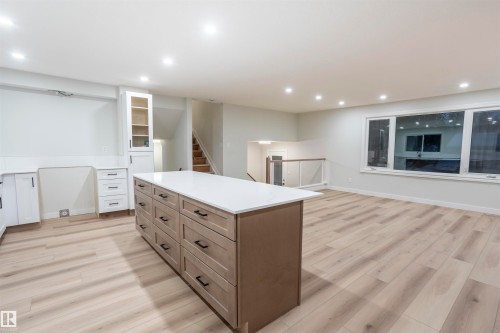 Kitchen featuring a kitchen island, light wood-style flooring, glass insert cabinets, white cabinets, and recessed lighting - 47 Manor Drive, Sherwood Park, AB - Indoor