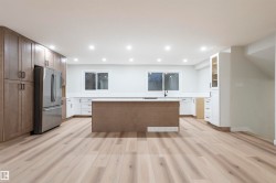 Kitchen with freestanding refrigerator, a center island, light wood-style flooring, recessed lighting, and glass insert cabinets - 