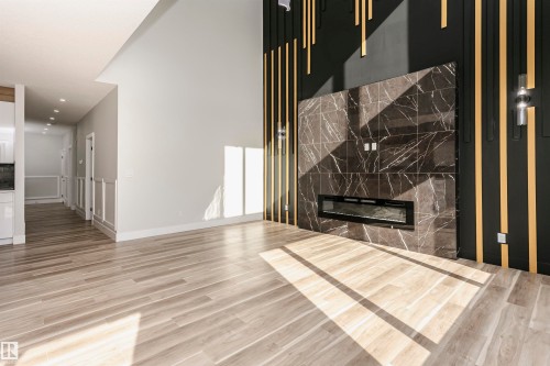 Unfurnished living room with LVP finished floors, a premium fireplace, and recessed lighting - 1723 19 Street, Edmonton, AB - Indoor With Fireplace