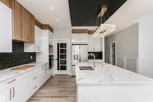 Kitchen with white cabinetry, light stone countertops, pendant lighting and recessed lighting - 1723 19 Street, Edmonton, AB - Indoor Photo Showing Kitchen With Double Sink With Upgraded Kitchen