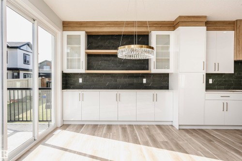 Kitchen with white cabinets, glass insert cabinets, pendant lighting, and light wood-style flooring - 1723 19 Street, Edmonton, AB - Indoor