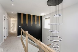 Hallway featuring an upstairs landing, light carpet, and recessed lighting - 