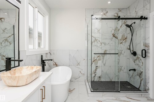 Full bath featuring marble finish floors, vanity, a freestanding tub, a marble finish shower, and tile walls - 1723 19 Street, Edmonton, AB - Indoor Photo Showing Bathroom