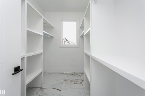 Walk in closet featuring light marble finish floors - 1723 19 Street, Edmonton, AB - Indoor With Storage