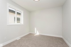 Empty room featuring light carpet and baseboards - 