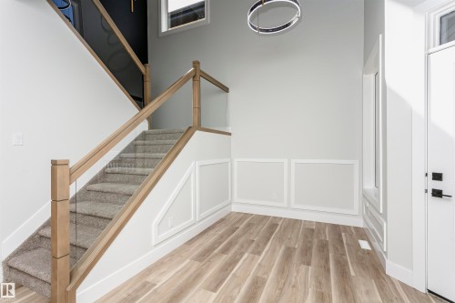 Staircase with wood finished floors, a decorative wall, and wainscoting - 1723 19 Street, Edmonton, AB - Indoor Photo Showing Other Room