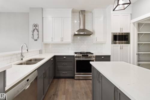 Kitchen featuring gray cabinets, light stone counters, and stainless steel appliances - 107 Cresthaven Grove, Ardrossan, AB - Indoor Photo Showing Kitchen With Double Sink With Upgraded Kitchen