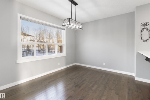 Unfurnished dining area featuring dark wood finished floors and a chandelier - 107 Cresthaven Grove, Ardrossan, AB - Indoor Photo Showing Other Room