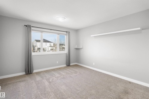 Spare room with baseboards and light carpet - 107 Cresthaven Grove, Ardrossan, AB - Indoor Photo Showing Other Room