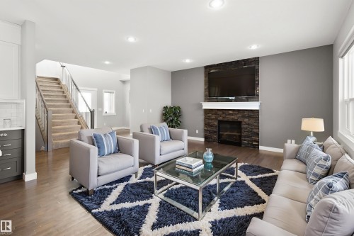 Living area with wood finished floors, a fireplace, stairway, plenty of natural light, and recessed lighting - 107 Cresthaven Grove, Ardrossan, AB - Indoor Photo Showing Living Room With Fireplace