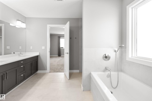 Bathroom featuring a bath, double vanity, and light tile patterned floors - 107 Cresthaven Grove, Ardrossan, AB - Indoor Photo Showing Bathroom