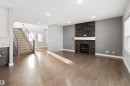 Unfurnished living room with stairway, a fireplace, dark wood-style flooring, plenty of natural light, and recessed lighting - 107 Cresthaven Grove, Ardrossan, AB  - Indoor Photo Showing Other Room With Fireplace 