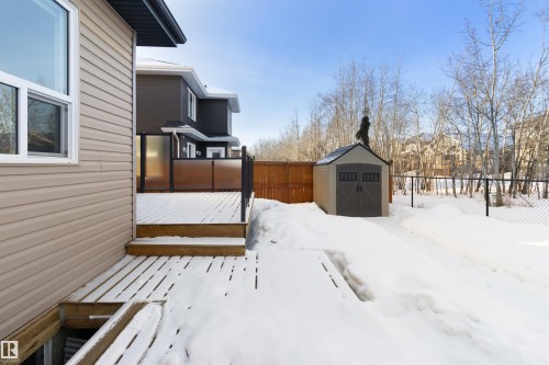 Yard layered in snow with a shed, a deck, and a fenced backyard - 107 Cresthaven Grove, Ardrossan, AB - Outdoor With Exterior