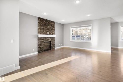Unfurnished living room with light wood-style flooring, a fireplace, plenty of natural light, and recessed lighting - 107 Cresthaven Grove, Ardrossan, AB - Indoor Photo Showing Living Room With Fireplace