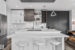 Kitchen featuring open shelves, dark wood finished floors, light stone countertops, freestanding refrigerator, and recessed lighting - 