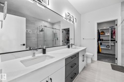 Bathroom with a walk in closet, a shower stall, and double vanity - 