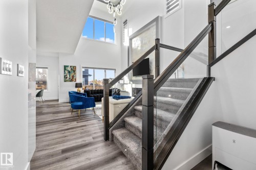 Stairs with a high ceiling, healthy amount of natural light, and wood finished floors - 5304 Kimball Place, Edmonton, AB - Indoor Photo Showing Other Room