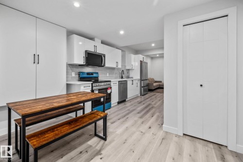 Kitchen with backsplash, appliances with stainless steel finishes, white cabinets, light wood-style flooring, and recessed lighting - 5304 Kimball Place, Edmonton, AB - Indoor Photo Showing Kitchen