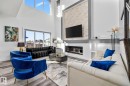 Living room featuring a high ceiling, wood finished floors, healthy amount of natural light, and a glass covered fireplace - 5304 Kimball Place, Edmonton, AB  - Indoor Photo Showing Living Room With Fireplace 
