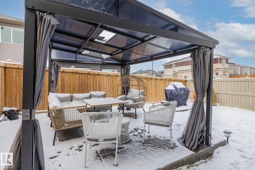 Snow covered patio with an outdoor hangout area, a fenced backyard, a wooden deck, and a grill - 5304 Kimball Place, Edmonton, AB - Outdoor With Deck Patio Veranda With Exterior