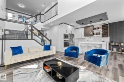 Living area featuring stairway, light wood finished floors, a high ceiling, and recessed lighting - 