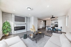 Living area featuring dark wood-style flooring, a large fireplace, and recessed lighting - 