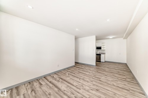 Unfurnished living room featuring light wood-style floors and baseboards - 4B 13230 Fort Road, Edmonton, AB - Indoor Photo Showing Other Room
