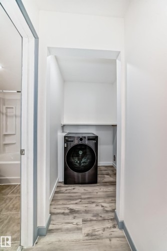 Laundry room featuring washer / clothes dryer and light wood-style flooring - 4B 13230 Fort Road, Edmonton, AB - Indoor Photo Showing Laundry Room
