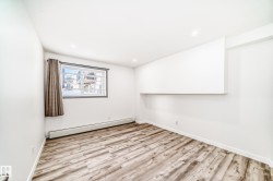 Unfurnished room featuring a baseboard heating unit, light wood-type flooring, and recessed lighting - 