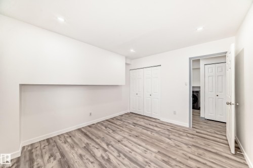 Unfurnished bedroom featuring light wood-style flooring, a closet, washer / clothes dryer, and recessed lighting - 4B 13230 Fort Road, Edmonton, AB - Indoor Photo Showing Other Room