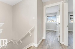 Hallway featuring an upstairs landing and light wood finished floors - 