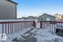 Snow covered deck featuring a fenced backyard and a residential view - 