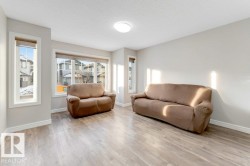 Living area featuring light wood-type flooring and a textured ceiling - 