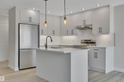 Kitchen featuring appliances with stainless steel finishes, recessed lighting, a center island with sink, pendant lighting, and light wood finished floors - 