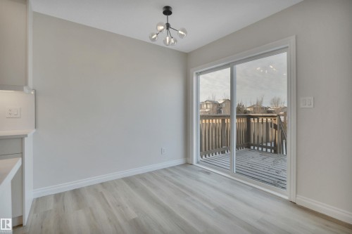 Unfurnished dining area with light wood-style flooring and a chandelier - 457 Aster Close, Leduc, AB - Indoor Photo Showing Other Room