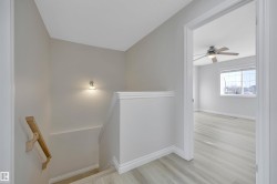 Stairs featuring wood finished floors and a ceiling fan - 