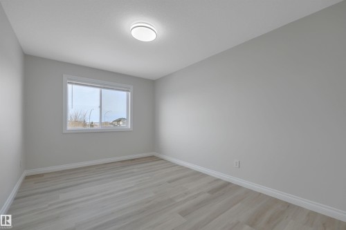 Unfurnished room featuring baseboards and light wood finished floors - 457 Aster Close, Leduc, AB - Indoor Photo Showing Other Room