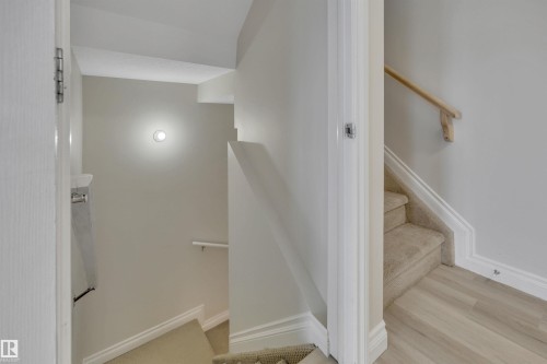 Stairway featuring baseboards and wood finished floors - 457 Aster Close, Leduc, AB - Indoor