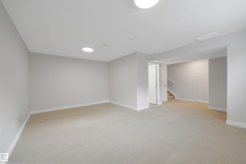 Finished below grade area with light colored carpet and stairway - 457 Aster Close, Leduc, AB - Indoor Photo Showing Other Room