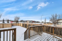 Snow covered deck featuring a residential view and a fenced backyard - 