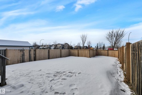 Yard covered in snow featuring a fenced backyard and a residential view - 457 Aster Close, Leduc, AB - Outdoor