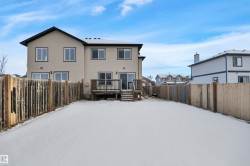 Snow covered property featuring a fenced backyard and a wooden deck - 